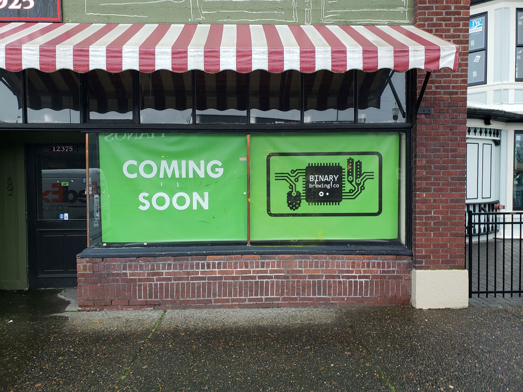 Coming soon sign in window of Binary Brewing Co. shop window