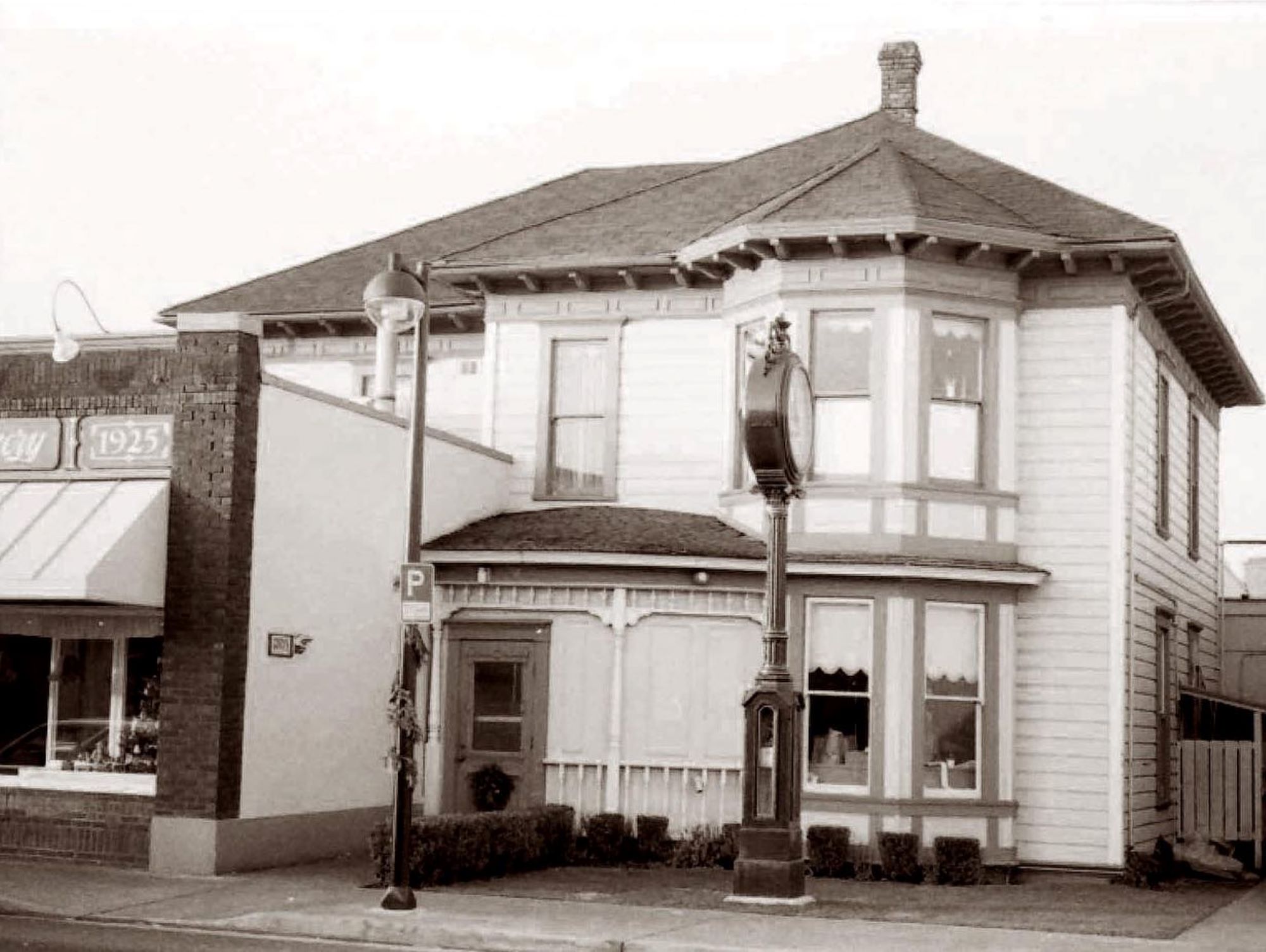 Bakery Blocks Victorian house with giant clock on street and lamppost