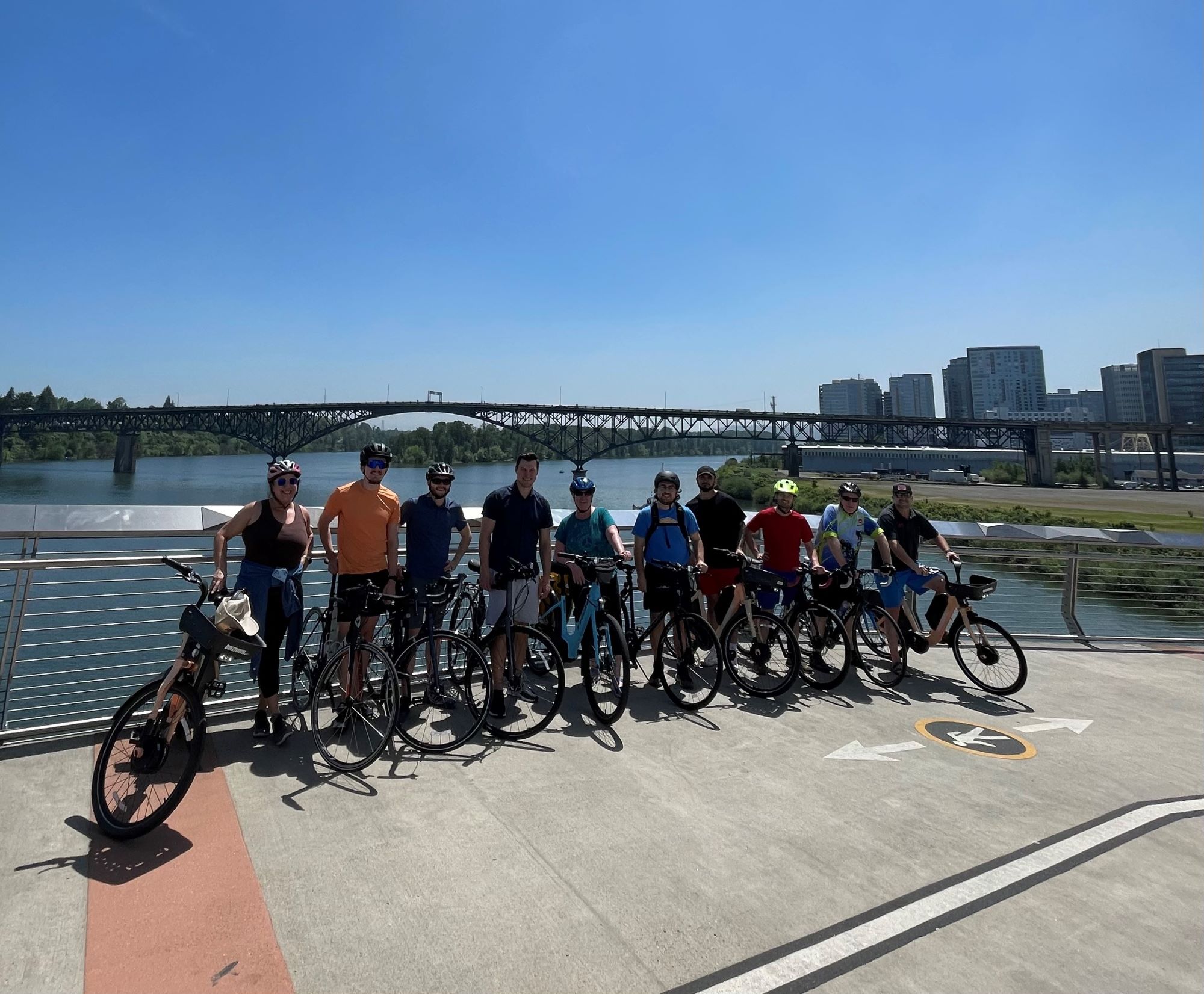 VLMK Group Bike Ride VLMK Staff on a group bike ride posing for a photo on the pedestrian bridge