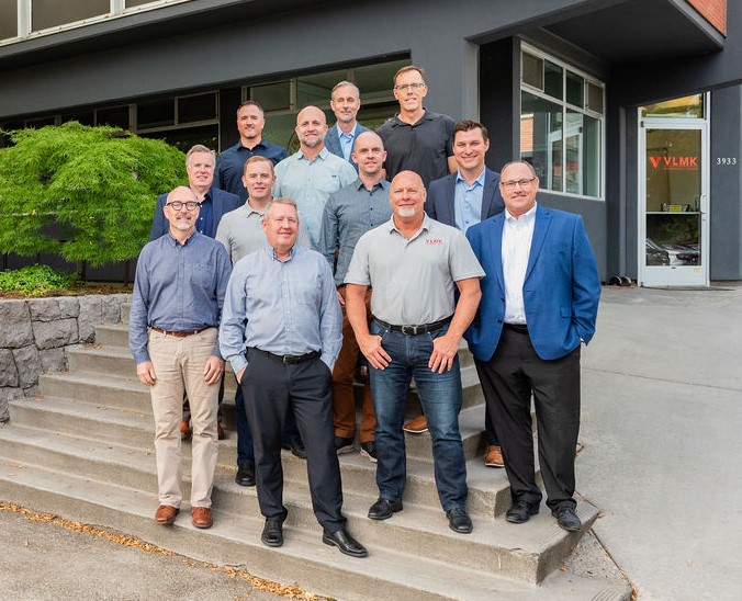 VLMK Partners Photo of 12 white males in front of an office space